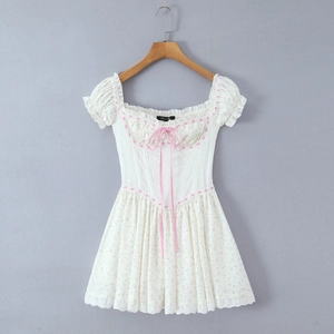 Robe courte fleurie avec dentelle rose et nœud papillon sur cintre en bois