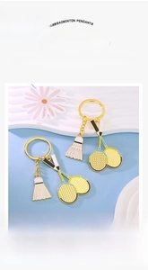 Détail du porte-clés raquette de badminton dorée avec finitions en émail coloré