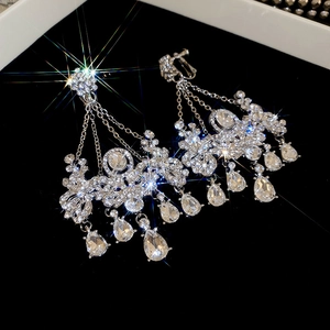 Vue rapprochée de boucles d'oreilles pampilles en argent avec strass brillants et fleurs