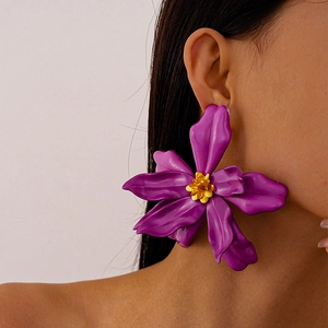 Macro detail of large purple acrylic flower earring with amber bead stamen on model