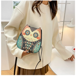 Detail of cute owl shape crossbody bag with bohemian patterns and slim shoulder strap