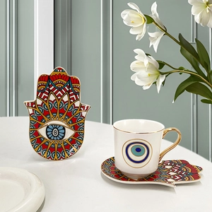 Detail of Hamsa Hand and Evil Eye ceramic coffee cup set with elegant gold-rimmed handles