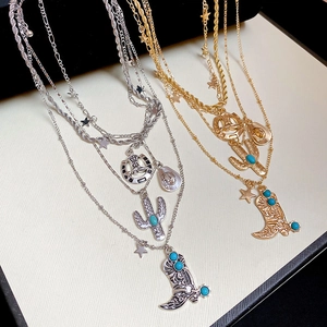 Detail of western cowboy multi-layer necklaces with boot and hat charms in gold and silver