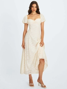 Détail d'une élégante robe en dentelle blanc cassé avec texture jacquard et manches bouffantes
