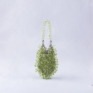 Detail of lime green handmade beaded handbag with crystal acrylic spikes and metal hardware
