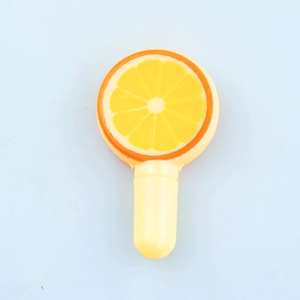 Detailed view of novelty orange lollipop style toy pen with realistic fruit top design