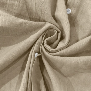 Close-up of khaki linen fabric texture showing breathable fibers and white button detail