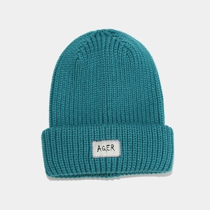 Thick ribbed knit beanie in blue with AQER logo tag for women's winter warmth