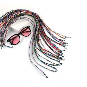 Detailed view of colorful bohemian braided eyewear straps displayed on a white stand