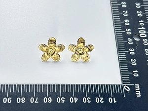 Detailed view of 15mm gold flower stud earrings with radial brushed texture on white background