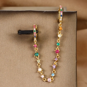 Detail of 18K gold plated earring chain with multi-colored zircons on a jewelry box