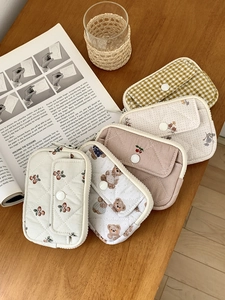 Flat lay of quilted cotton coin purses in cherry, bear, and plaid patterns on wood