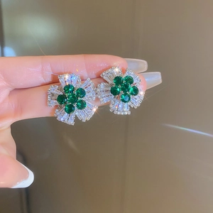 Macro shot of silver flower earrings with green center stone and sparkling zircons