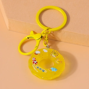 Detail of yellow donut keychain featuring cartoon patterns and anti-drowning text