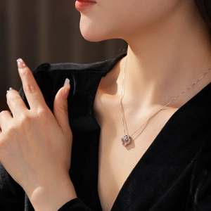 Silver flower knot necklace with cubic zirconia on model wearing black V-neck top
