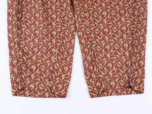 Gros plan du pantalon rouge à motif cachemire montrant la texture et l'ourlet