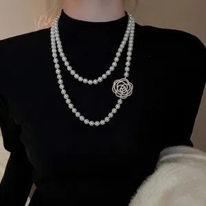 Élégant collier de perles à deux rangs orné d'un pendentif en forme de camélia scintillant
