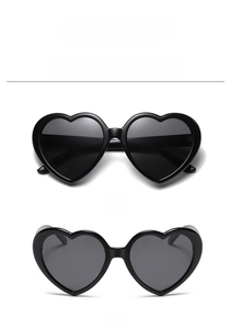 Detail view of black heart-shaped polarized sunglasses with sleek PC frame and dark lenses