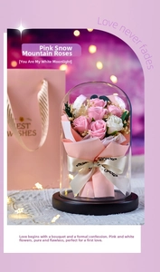 Close-up of pink roses in glass dome with wood base and matching gift bag