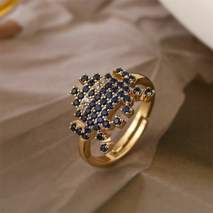 Detailed close-up of pixelated heart ring with blue and white zircon in gold plating