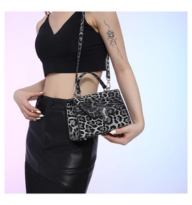 Detail of leopard print handbag featuring a metallic square buckle and a flap design