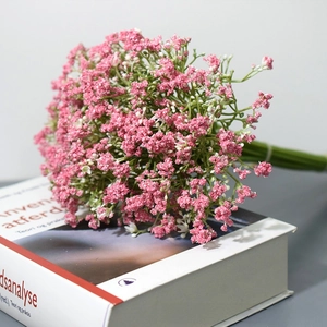 Detail view of artificial pink and white gypsophila bouquet with green stems and white ribbon