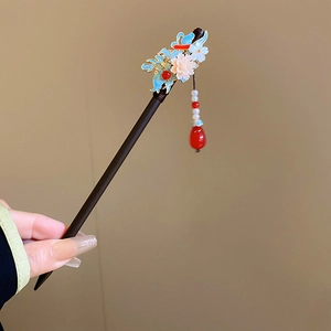 Detailed view of handmade wood hair pin with blue floral motif and pearl tassel