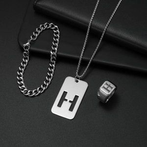 Detailaufnahme des silbernen Titanschmucksets mit H-Buchstabenkette und kubanischem Armband