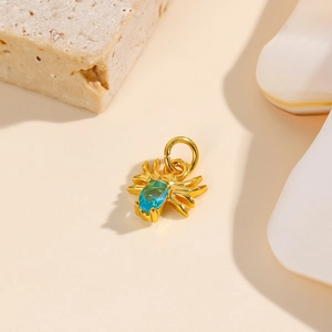 Detailed view of a gold spider pendant featuring an oval blue gemstone inlay for DIY jewelry