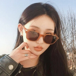 Retro amber square frame sunglasses with dark brown lenses worn by model outdoors
