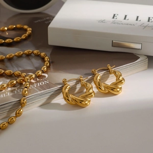 Elegant 18k gold plated twisted hoop earrings with beaded necklace on fashion magazine