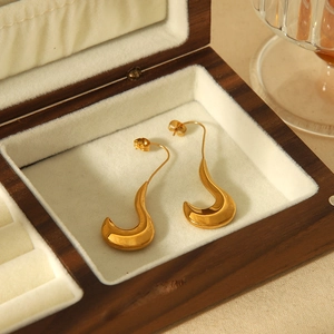 Polished 18k gold plated titanium steel flame-shaped earrings on a wooden jewelry box