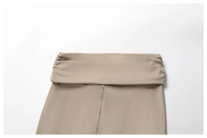 Détail d'un legging de yoga avec taille haute repliée beige et fronces sur les côtés
