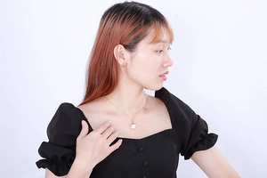 Detail view of a golden geometric jewelry set with earrings and a hexagonal pendant