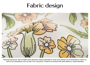 Gros plan du tissu floral avec des fleurs jaunes et orange sur un fond blanc pur