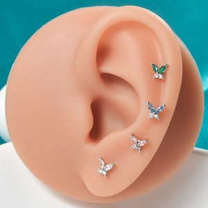 Minimalist butterfly zircon stud earrings set in four colors on silicone ear model