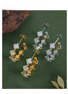 Detail of C-shaped titanium steel earrings with square-cut cubic zirconia in gold and silver