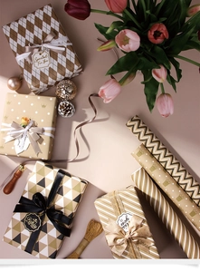 Detail view of gold-stamped gift wrapping paper with diverse geometric patterns and textures