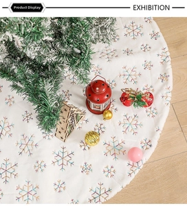 Detail of white plush Christmas tree skirt with rainbow sequin snowflake embroidery
