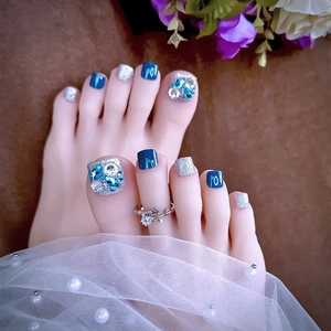 Unghie finte piedi blu e argento glitter con strass decorativi su sfondo elegante
