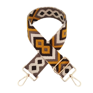Detailed weave of 5cm diamond jacquard bag strap with gold metal buckles on white background