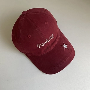 Close-up of burgundy baseball cap featuring Dashing embroidery and plaid star detail