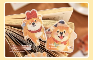 Gros plan d'autocollants Shiba Inu pailletés sur les pages d'un livre à lumière douce