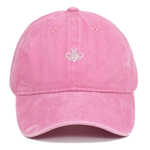 Close-up of a pink washed cotton baseball cap with detailed bee embroidery on the front