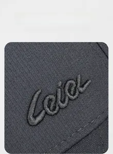 Macro shot of 3D embroidered logo on textured dark grey twill fabric for men baseball cap