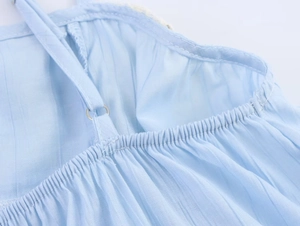Detail of light blue lace top with adjustable metal buckle on thin spaghetti straps