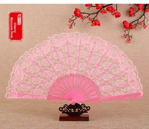Detail of pink lace folding fan with gold scroll patterns and cherry blossom accents