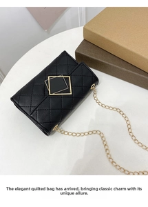 Top view of black quilted PU chain bag with gold square buckle on a white surface