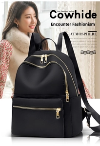 Close-up of black Oxford cloth backpack with premium golden zippers and dual zip compartments