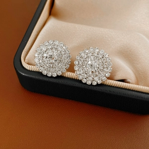 Vue macro de boucles d'oreilles diamants ronds dans un écrin noir avec doublure soie